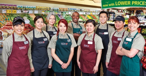 In this image, a group of Safeway employees standing and posing together for a photo.